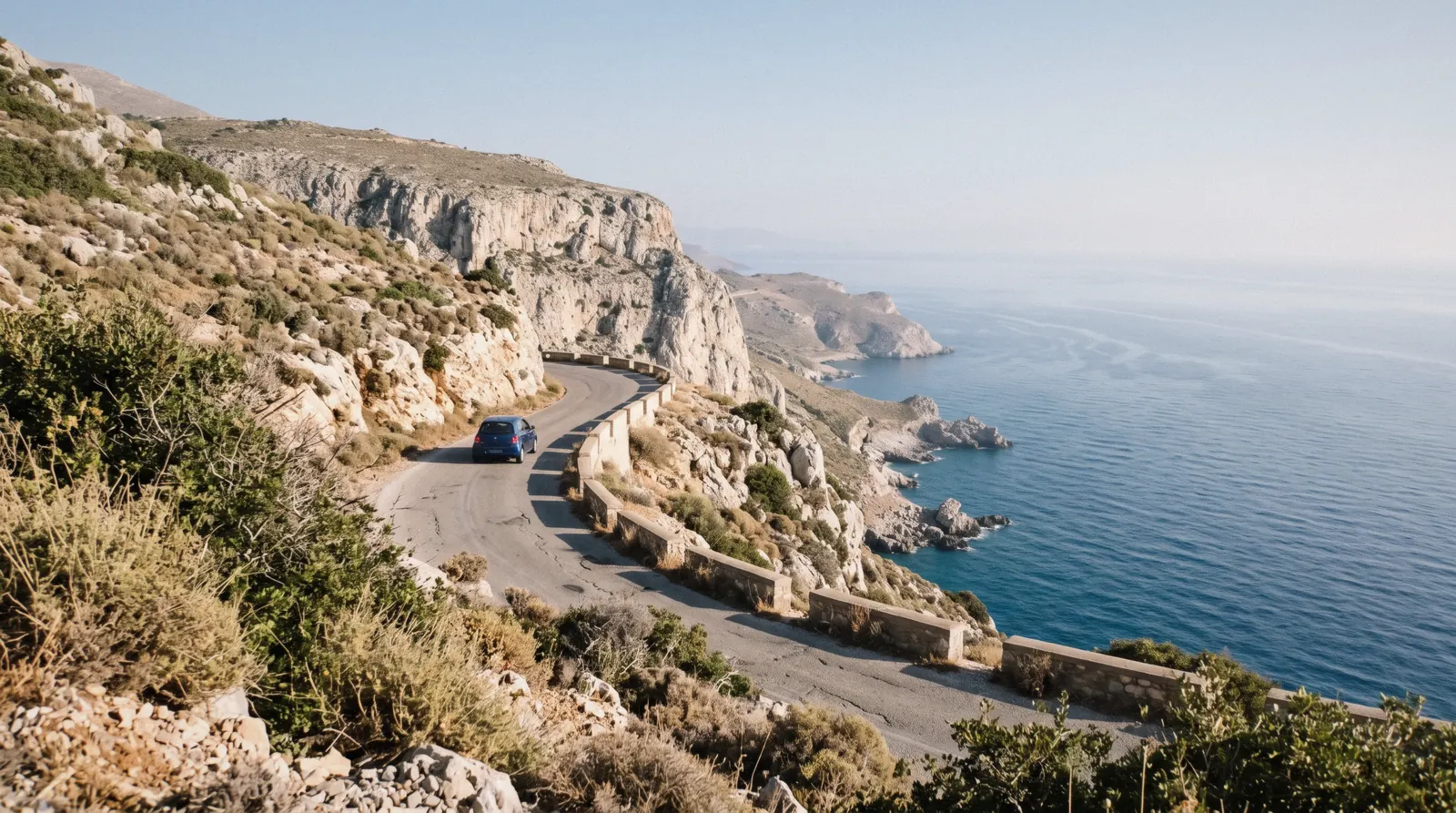 A coastal road winding above the Aegean sea on a Crete day trip route