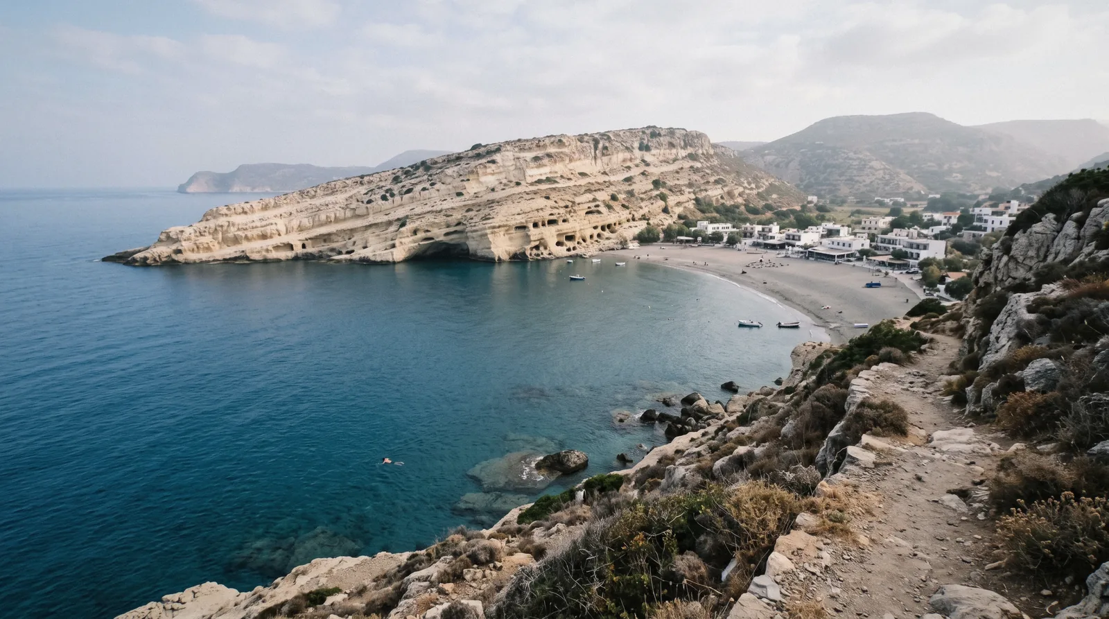 The sandstone cliff honeycombed with rock-cut caves above the sand at Matala beach, Crete