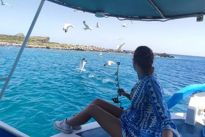 Small fishing boat in the Elounda gulf on a fishing and swimming trip, Crete Greece