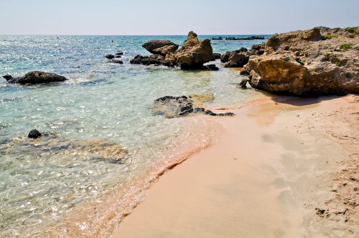 Shallow lagoon crossing to the islet at Elafonisi pink sand beach, Crete